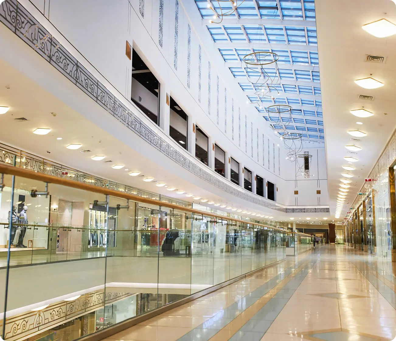 Spacious, modern shopping mall with glass ceiling.